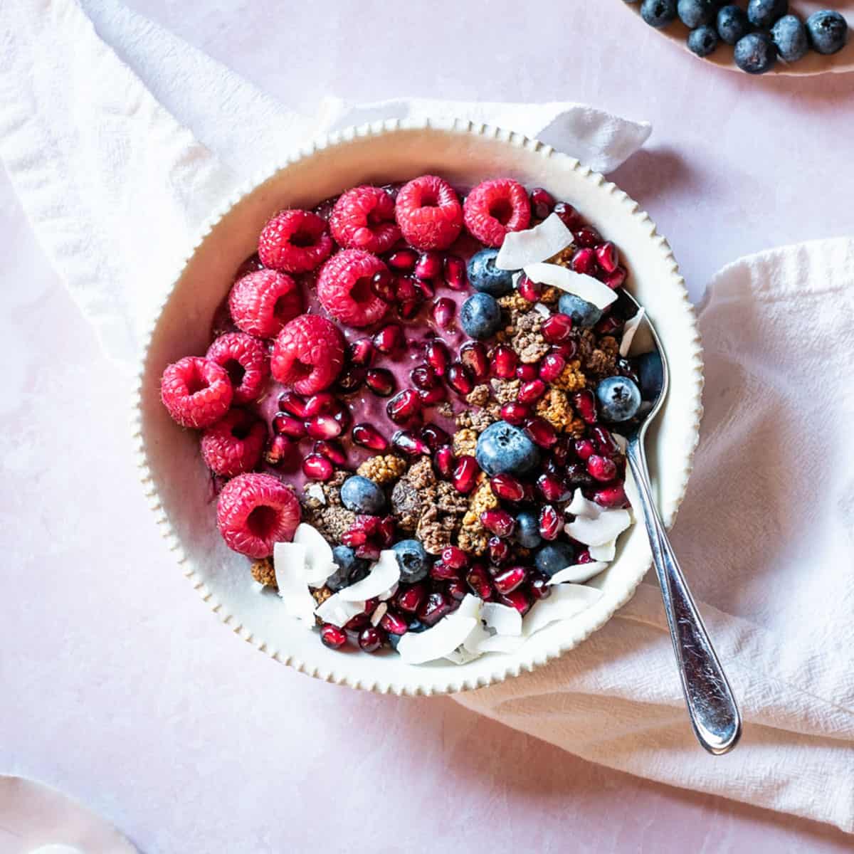 top down shot of yogurt in bowl with granola and berries