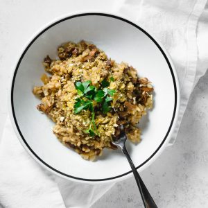 wild mushroom and leek risotto in bowl with fork