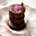 Side view of stack of chocolate peanut butter cups with salt on top