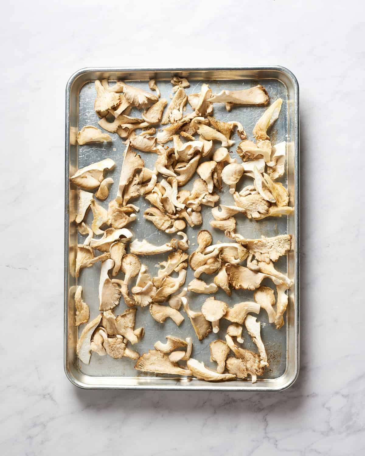 overhead view of raw oyster mushrooms on baking sheet