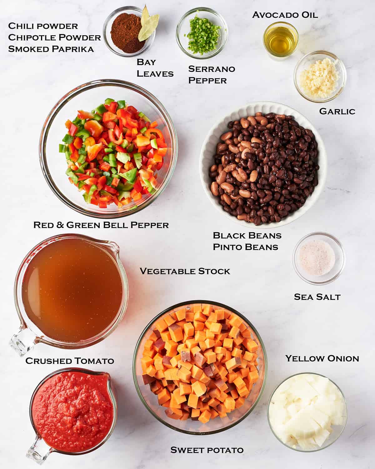 Overhead view of ingredients for sweet potato and black bean stew on marble background