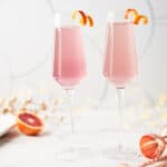 side view of 2 glasses filled with blood orange french 75