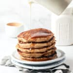 Stack of easy vegan banana oat pancakes on white plates.