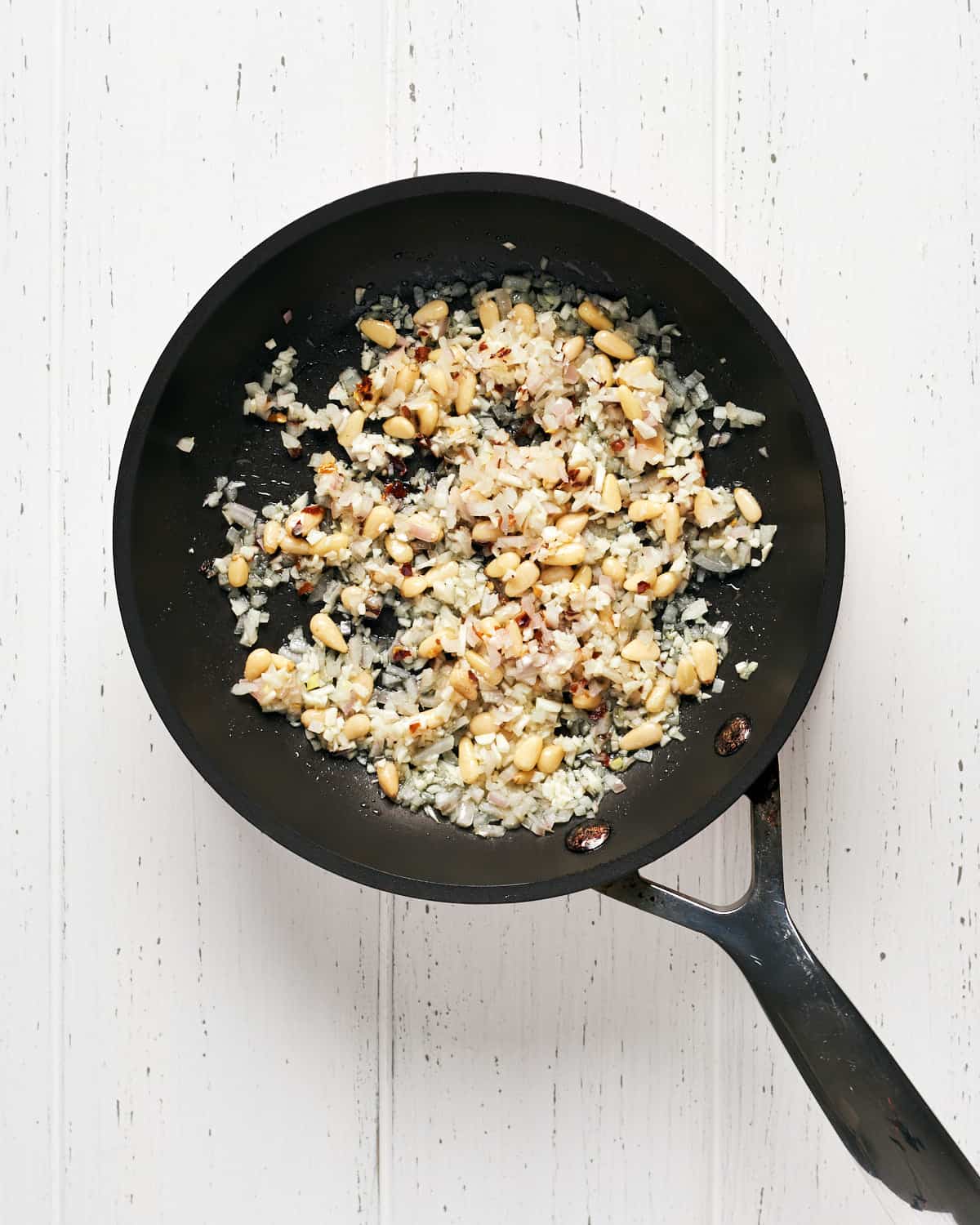 sauteing ingredients on saucepan to make pasta with peas