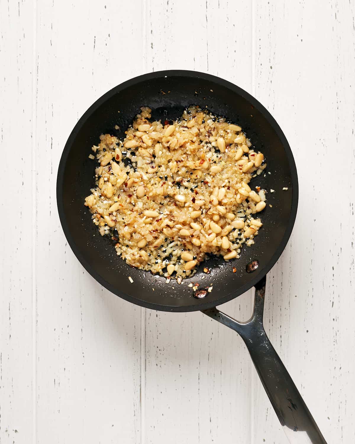 Overhead view of sauteing ingredients until golden on saucepan.