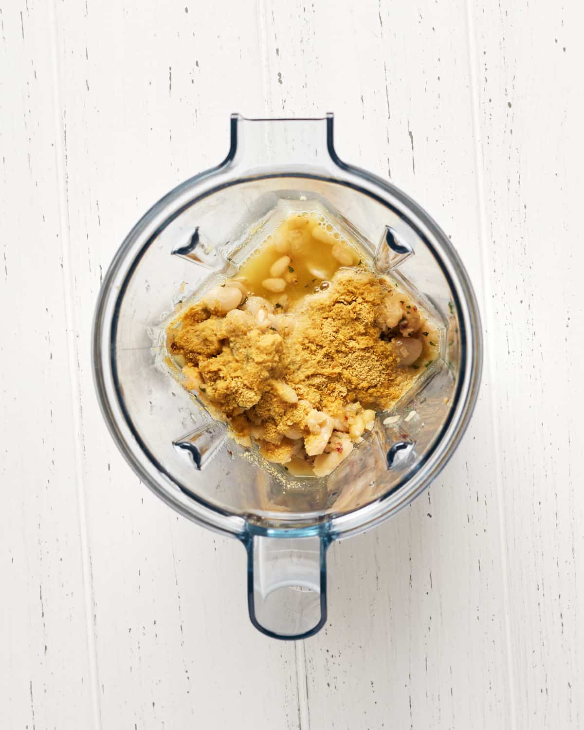 Overhead view of ingredients in blender to make a creamy sauce.