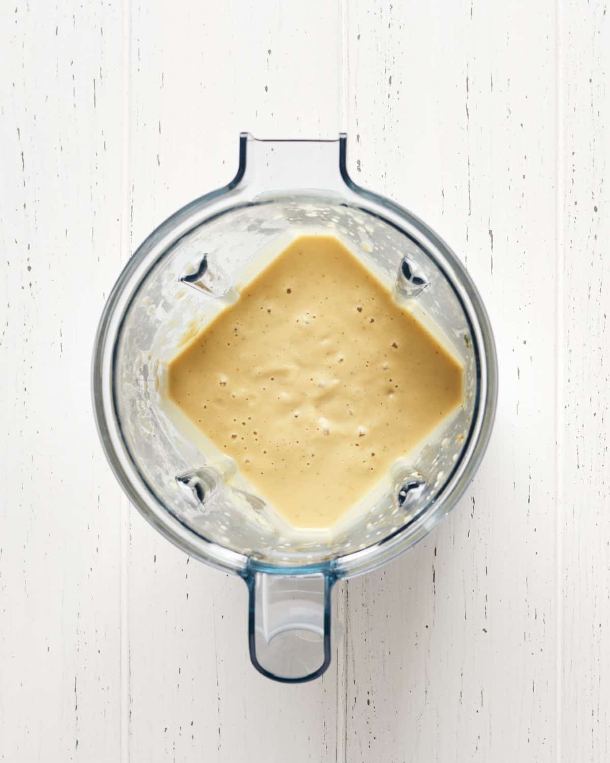 Overhead view of ingredients blended into sauce in blender to make pasta with peas.