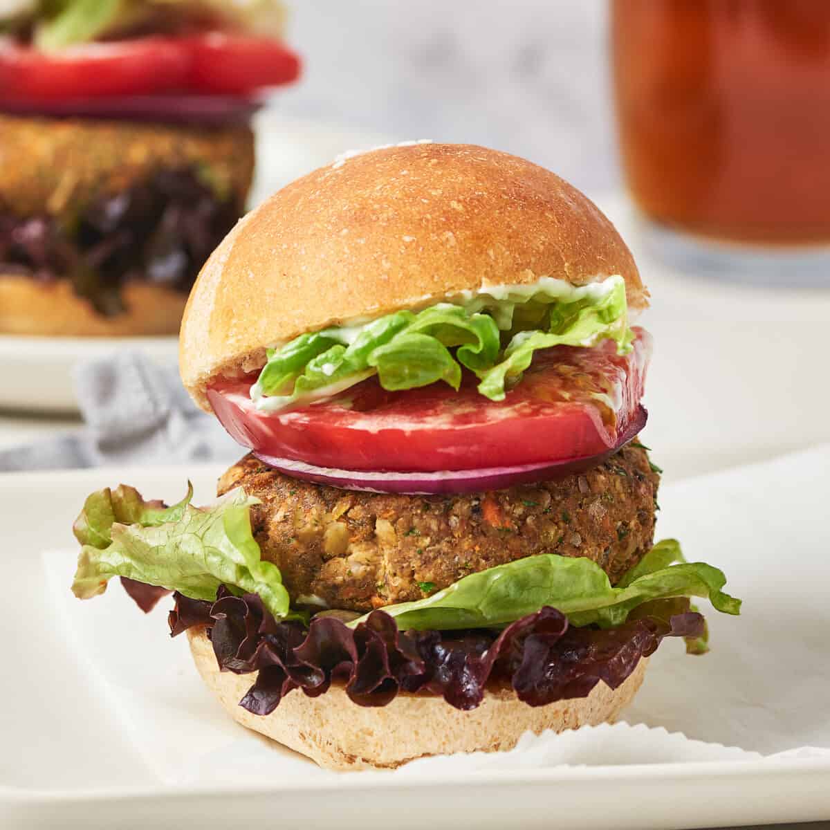 Side view of vegan lentil black bean burger on white platter