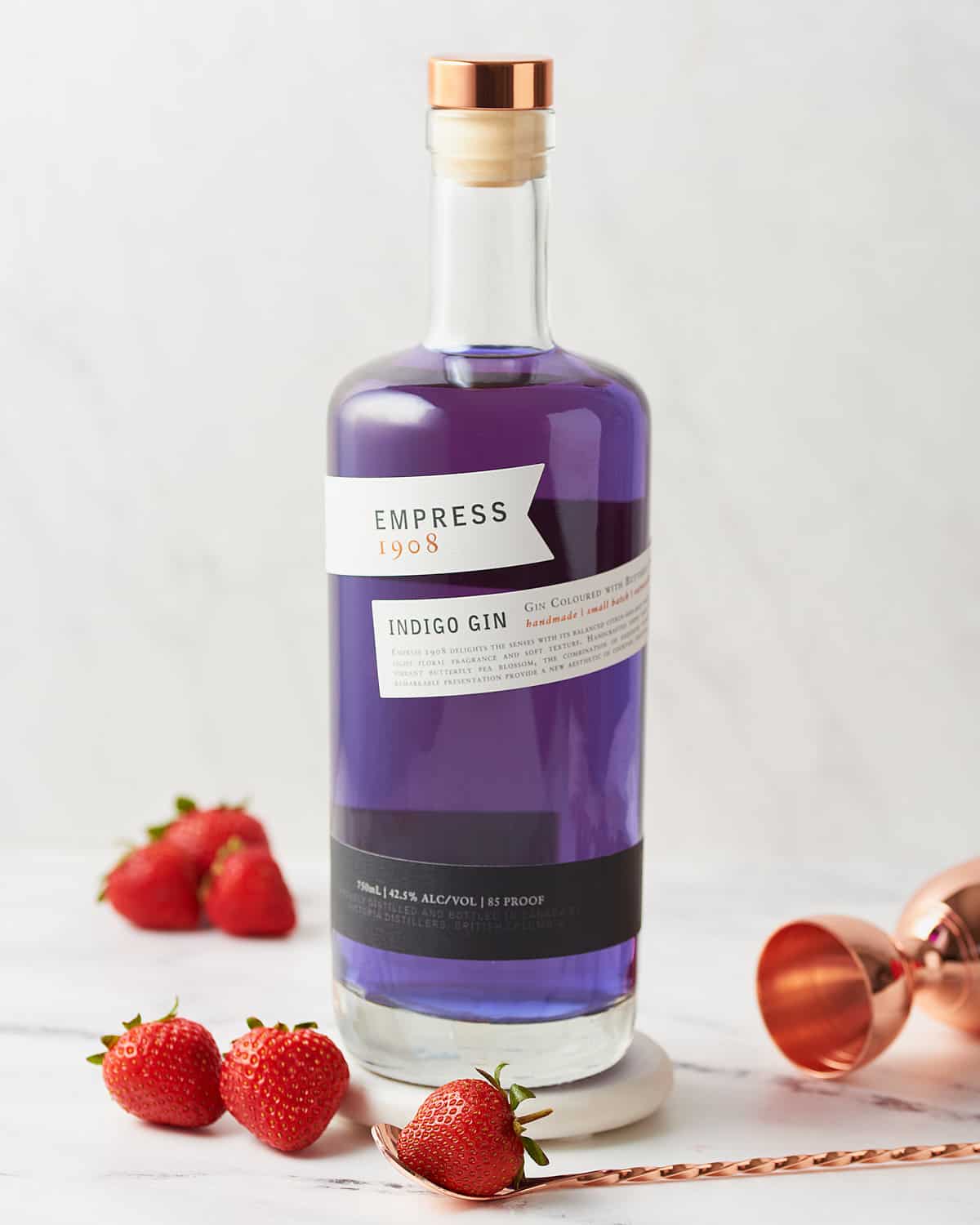 Bottle of Empress 1908 Gin with strawberries.
