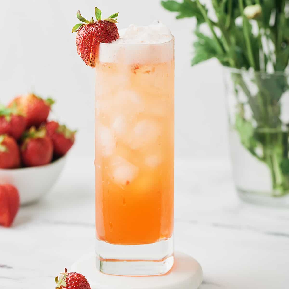 Glass of strawberry elderflower gin fizz with strawberry garnish.