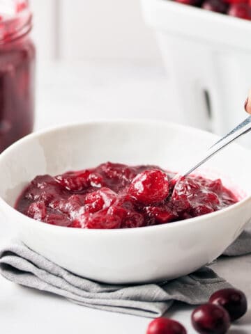 Side view of vegan cranberry sauce in small white bowl.
