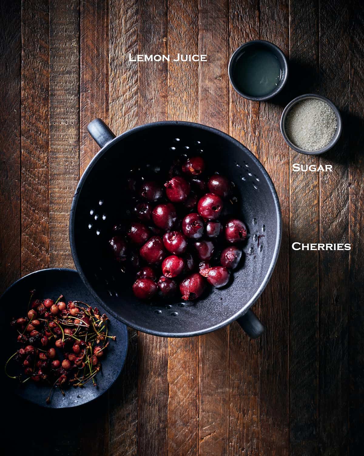 Ingredients to make cherry compote on wood background.