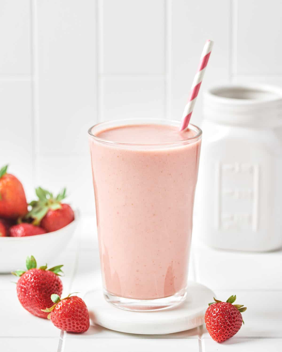 Glass of vegan strawberry milk with strawberries.