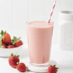 Glass of Vegan Strawberry milk with paper straw.