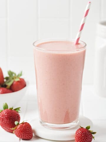 Glass of Vegan Strawberry milk with paper straw.