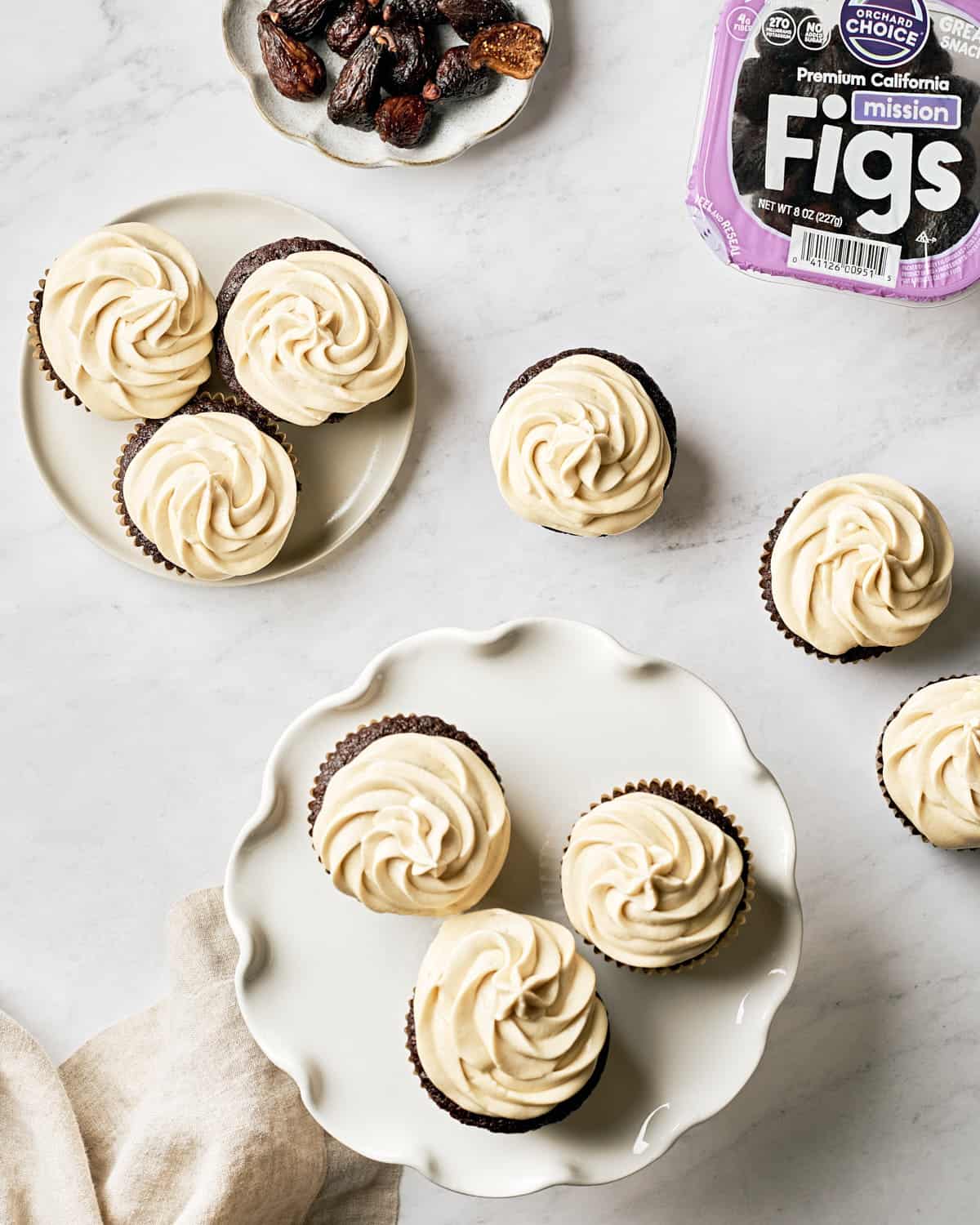 Overhead view of vegan chocolate fig cupcakes on marble background.