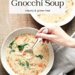 Overhead view of two bowls of vegan gnocchi soup on wood background with grey striped napkin.