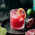 Side view of Blood Orange Pomegrnate Margarita garnished with slice of blood orange.