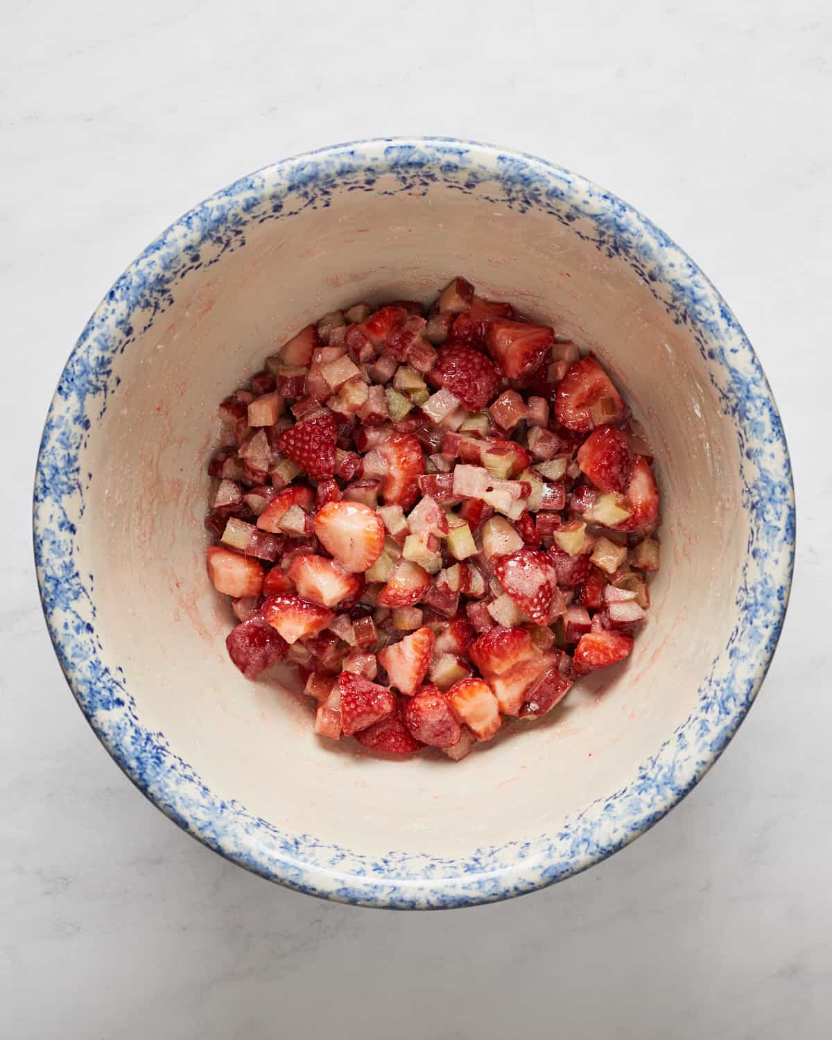 Overhead view of chopped strawberries and rhubarb pie filling in a large bowl.