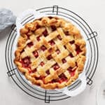 Overhead view of vegan strawberry rhubarb pie cooling on a rack.