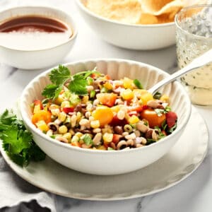 Bean Salad in a bowl with a fork on a marble surface with a grey napkin.