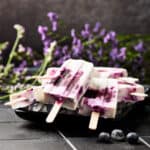 Side view of vegan blueberry yogurt popsicles made with gin.