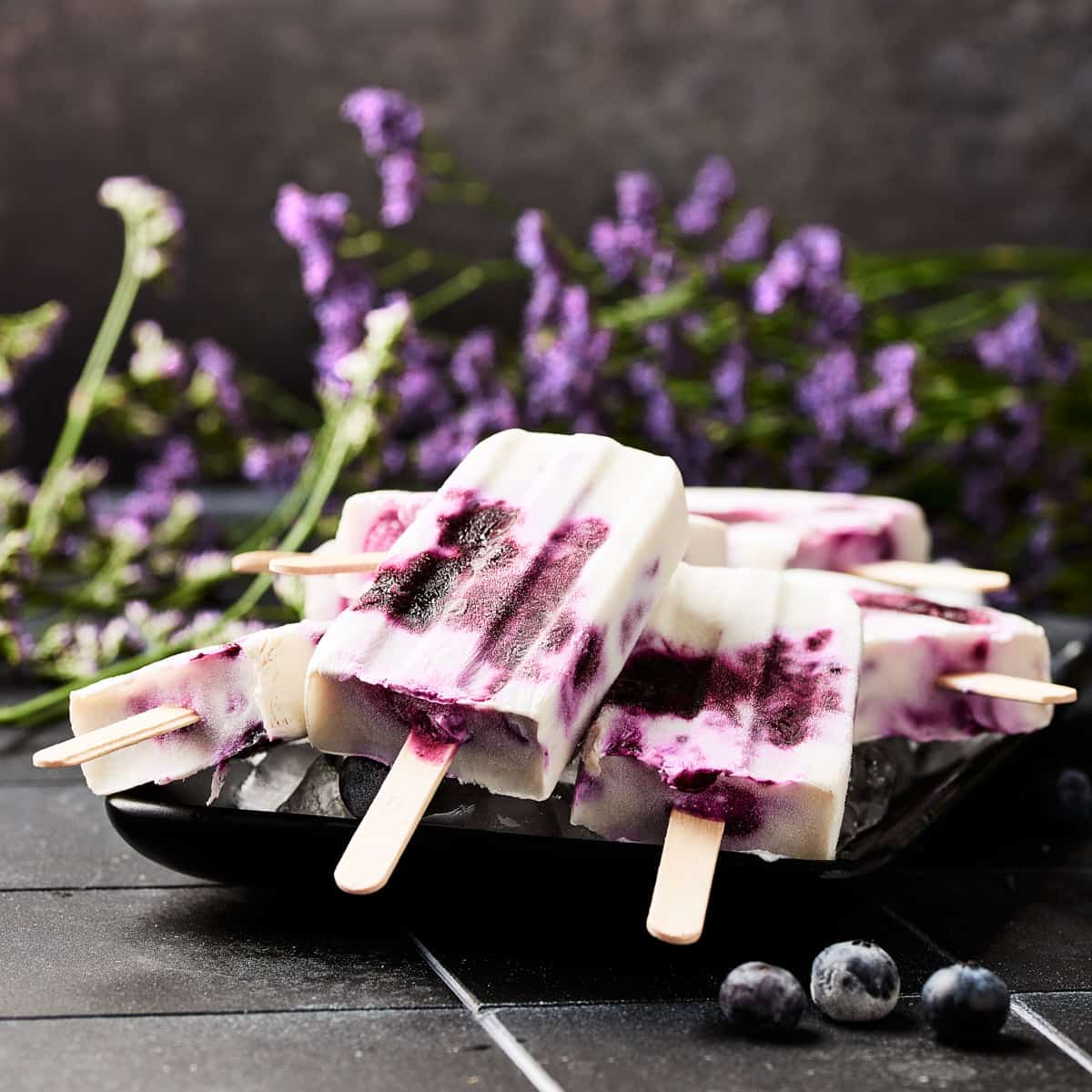 Side view of vegan blueberry yogurt popsicles made with gin.