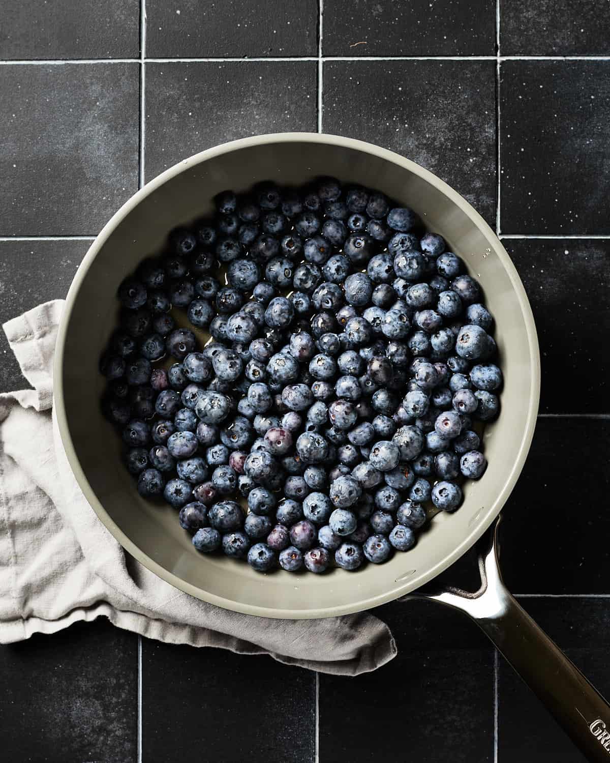 Overhead view of blueberries in saucepan with maple syrup.