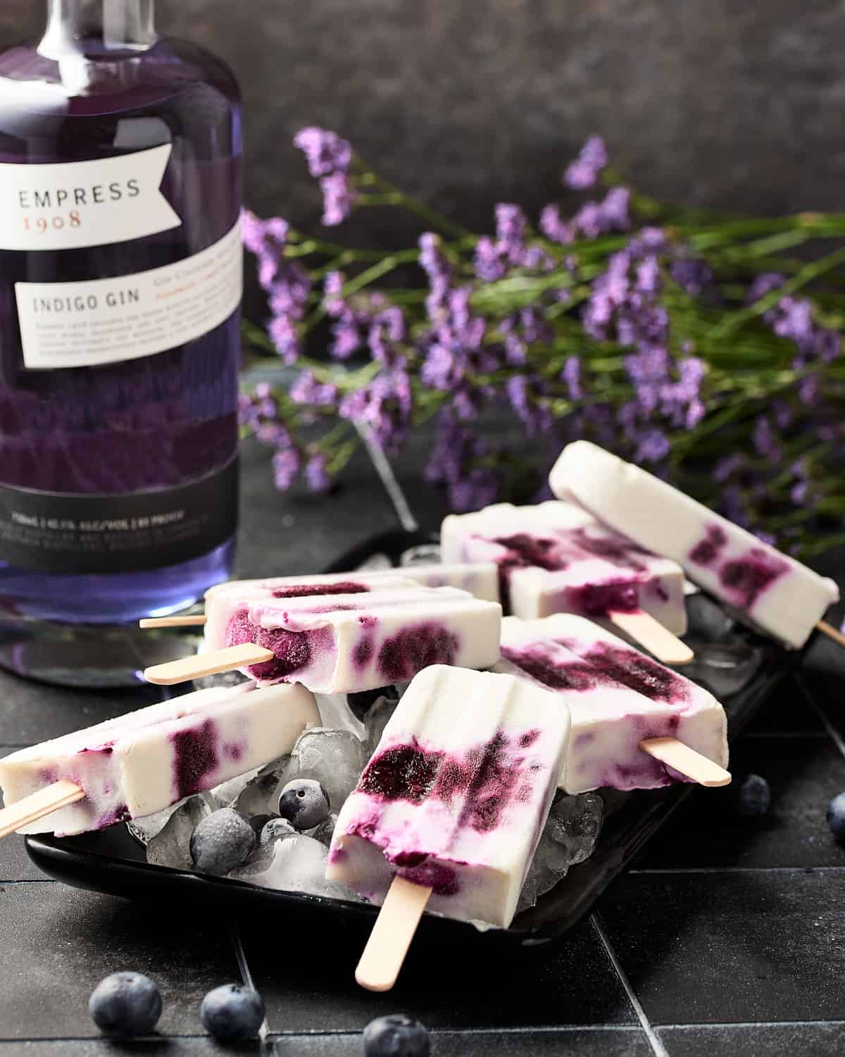 Side view of boozy vegan blueberry yogurt popsicles with gin.