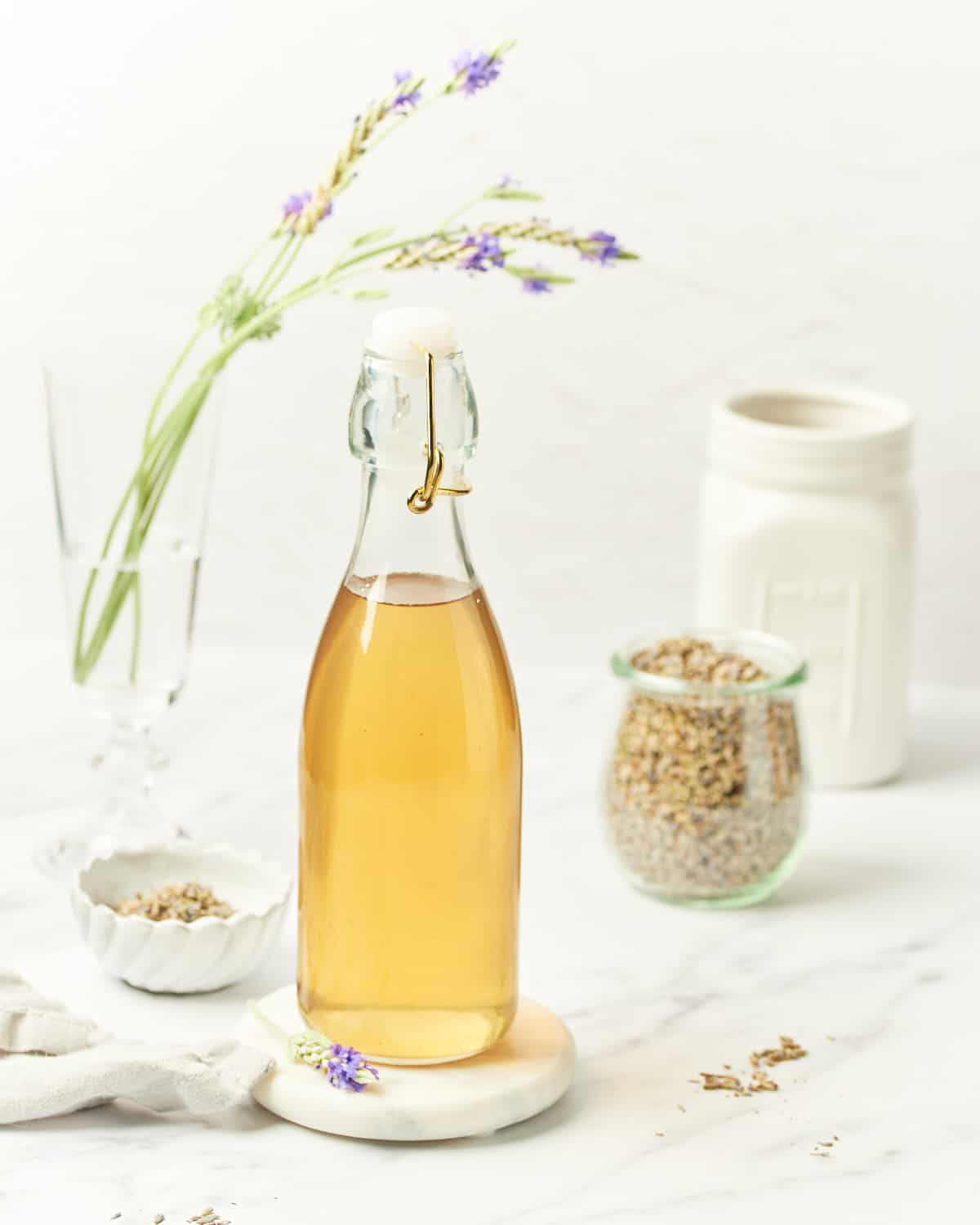 Side view of Lavender Simple Syrup in a glass bottle.