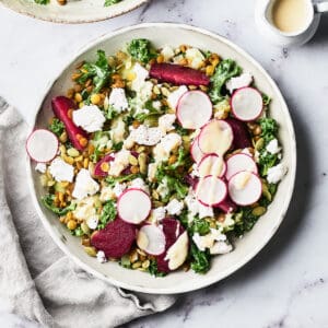 Overhead view of a bowl of roasted beet and kale salad with lentils and leeks.