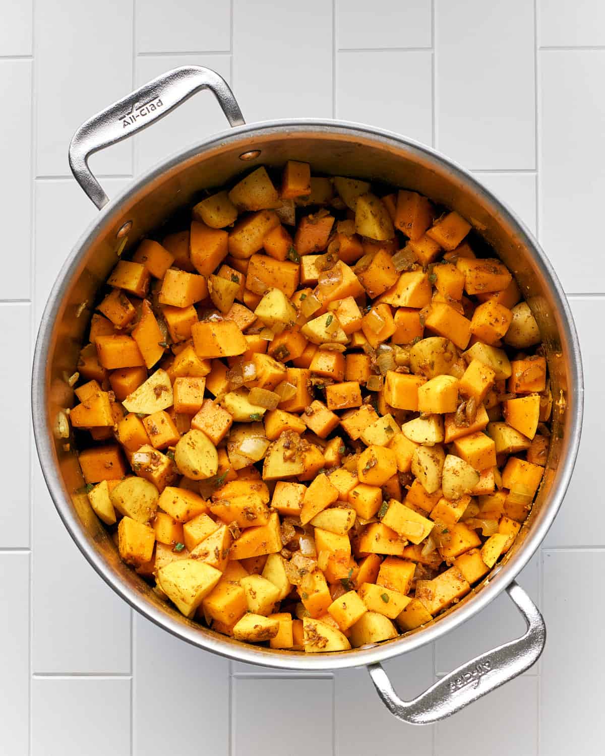 Overhead view of vegetables with spices to make vegan butternut squash curry soup.