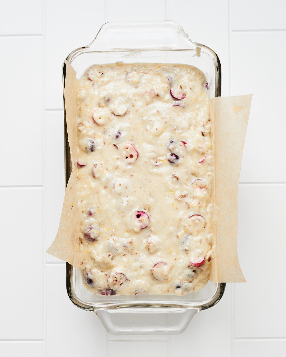 Overhead view of vegan cranberry orange bread batter in baking dish before baking.