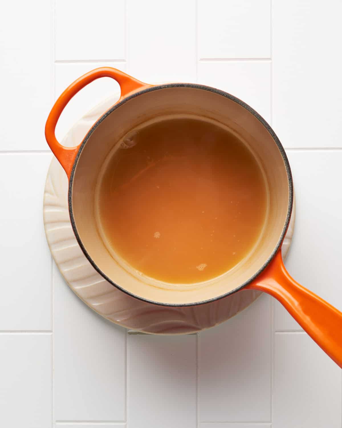 Overhead view of making apple cider reduction in a small saucepan.