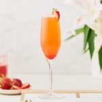 Side view of Rossini Cocktail garnished with a strawberry slice.