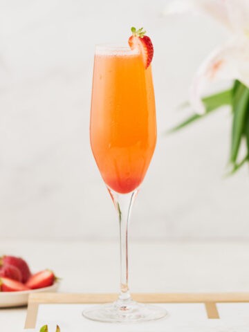 Side view of Rossini Cocktail garnished with a strawberry slice.