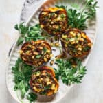 Overhead view of Roasted Stuffed Carnival Squash on a platter with fresh parsley.