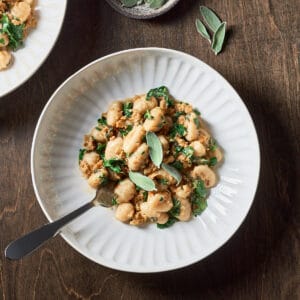 Overhead view of Gnocchi with Vegan Sausage and Browned Butter Sage on a wood background.