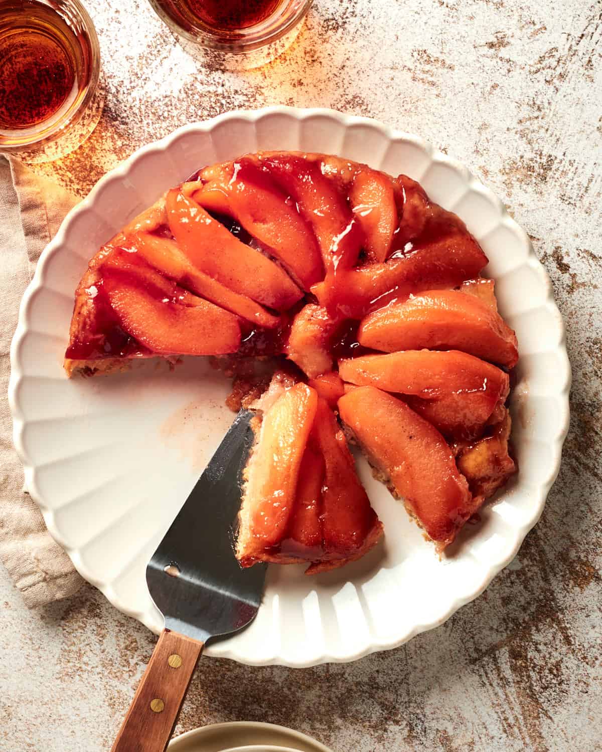 Overhead view of Vegan Quince Tarte Tatin on a white plate with a cake server.