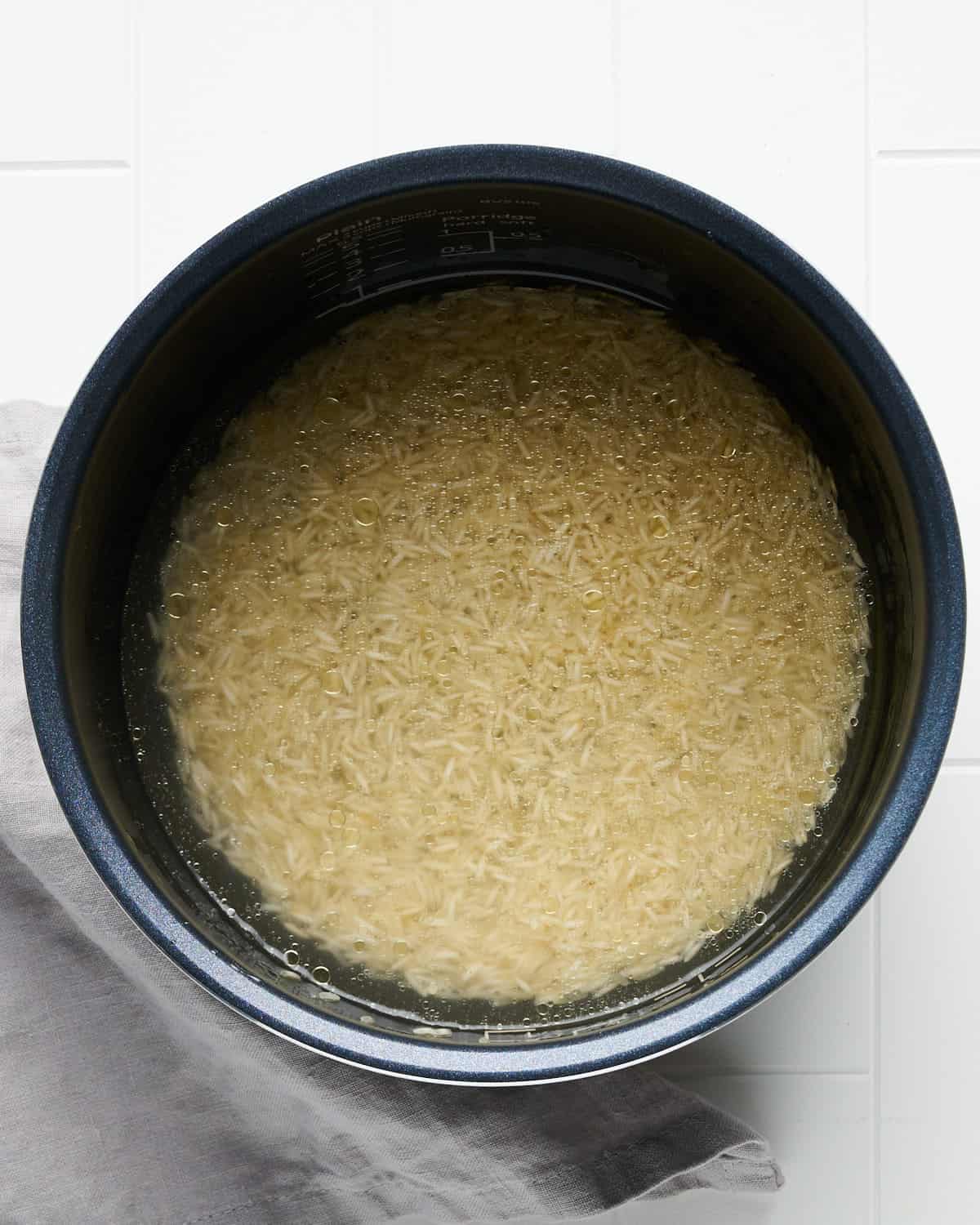 Overhead view of Long Grain White Rice in Rice Cooker Bowl to make Cilantro Lime Rice.