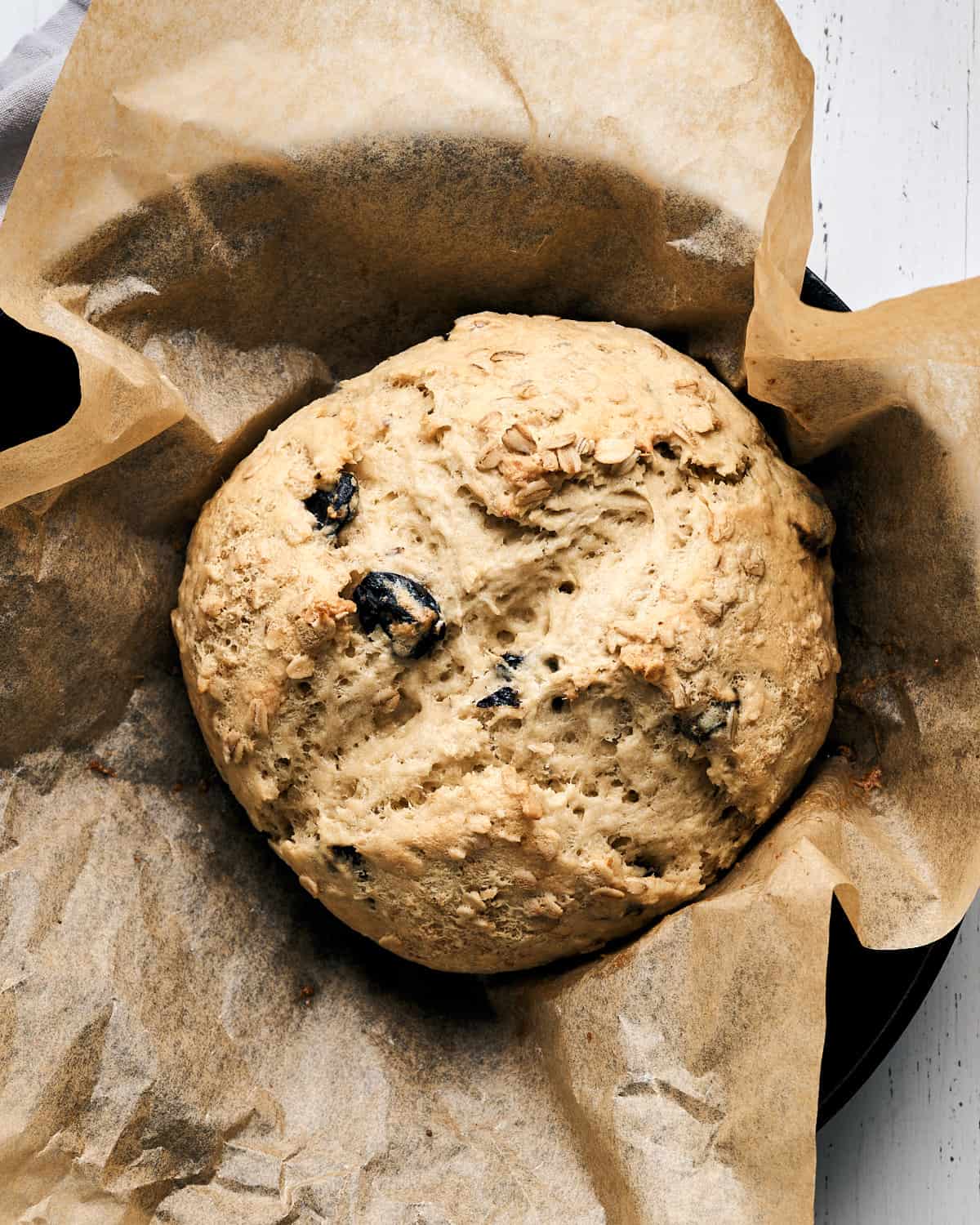 Baked Vegan Irish Soda Bread on parchment paper in a cast iron skillet.