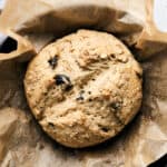 Baked Vegan Irish Soda Bread on parchment paper in a cast iron skillet.