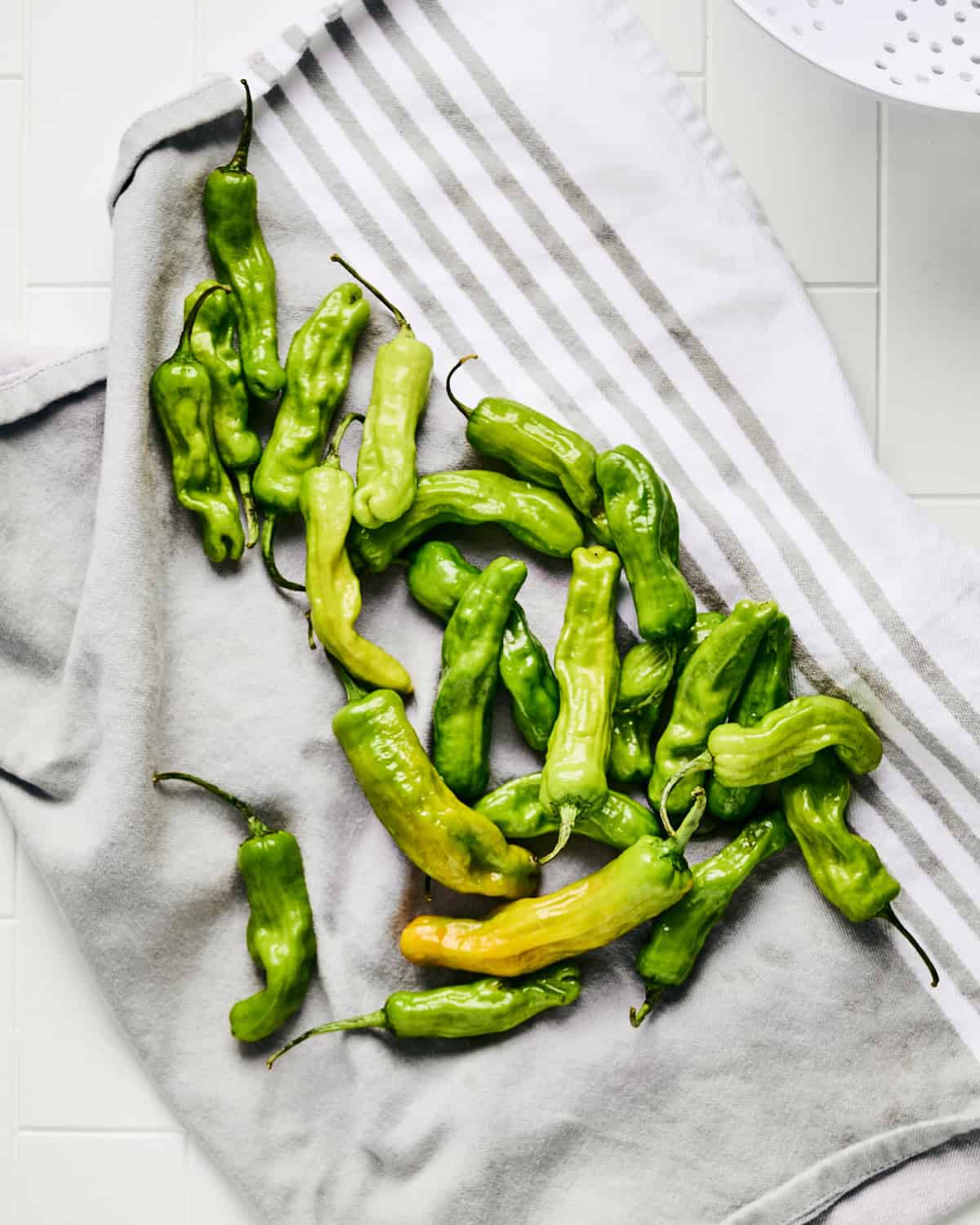 Drying rinsed shishito peppers on a clean kitchen towel.