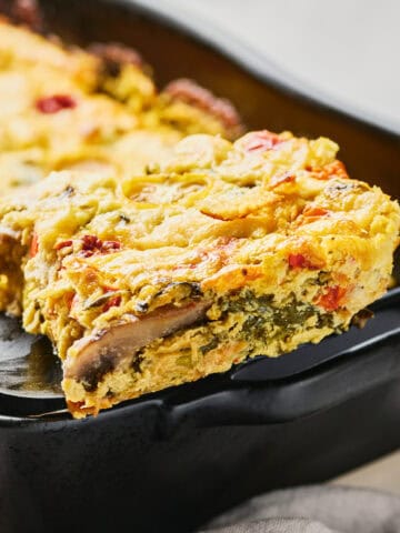 Slice of Vegan JUST Egg Frittata on a spatula near the casserole dish.