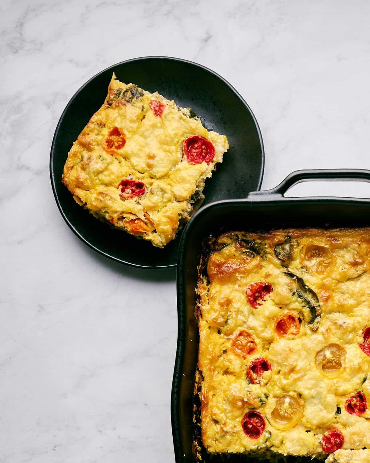 Slice of JUST Egg Frittata on a plate next to casserole dish.