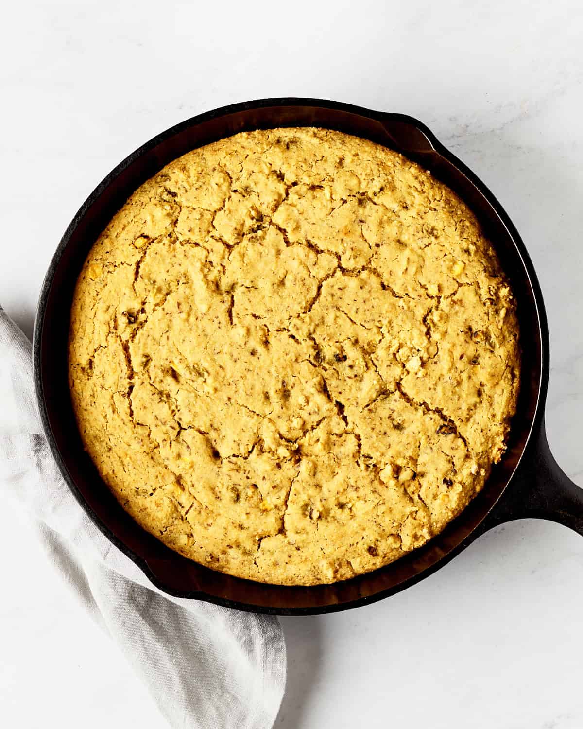 Baked vegan skillet cornbread southwestern style in a cast iron skillet.