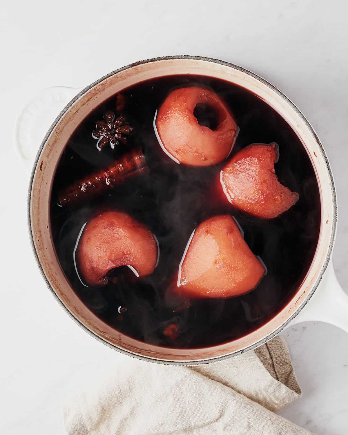 Four pears with cinnamon stick and star anise, and spices in red wine broth.