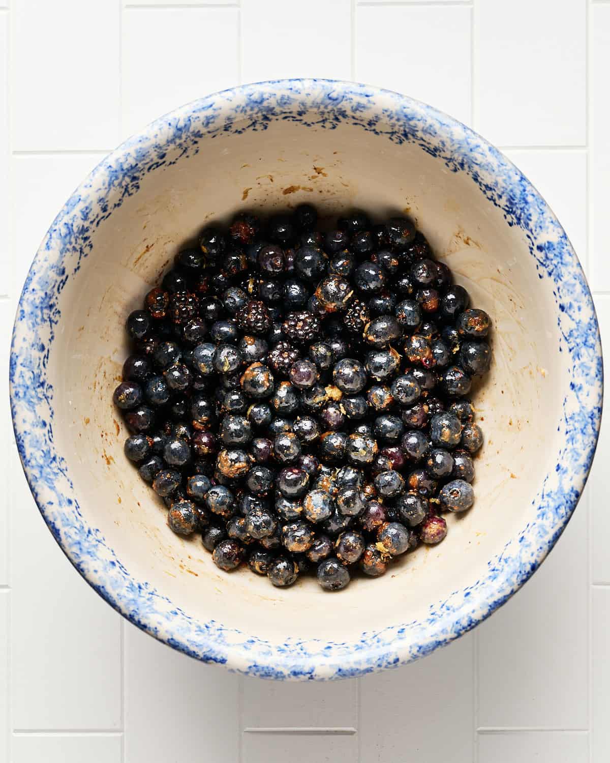 Berries combined in a large bowl with coconut sugar, lemon zest, lemon juice, and arrowroot powder.