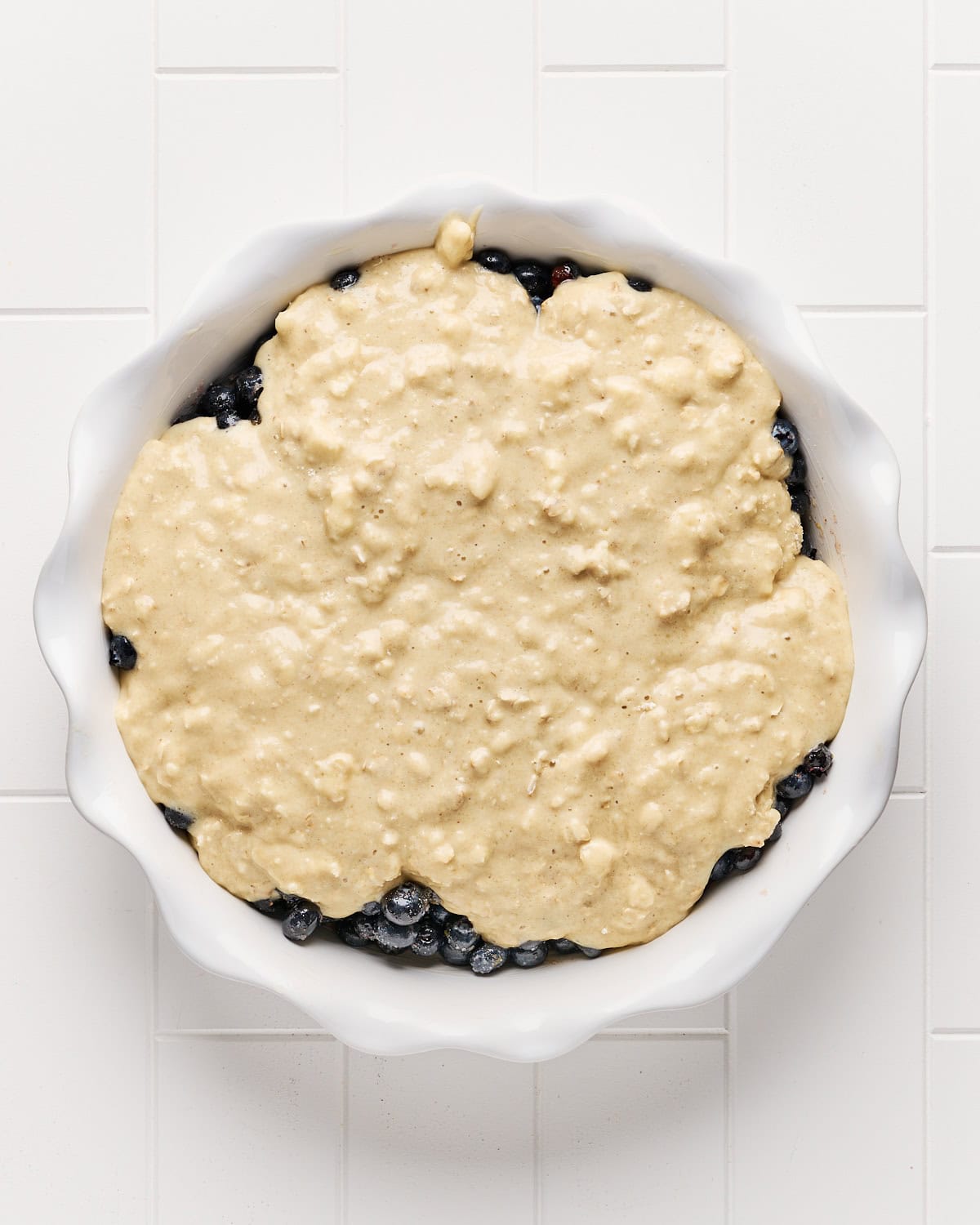 Unbaked vegan blueberry cobbler in a pie dish before baking.