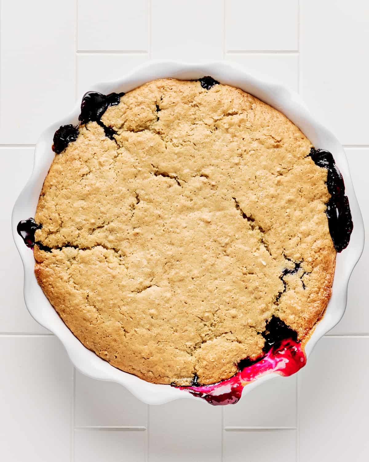 Baked vegan blueberry cobbler in a pie dish.